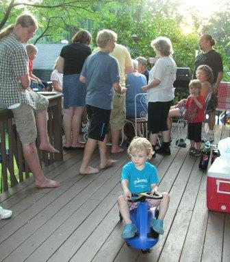 Thomas on his new Plasma car while everyone else enjoys cake