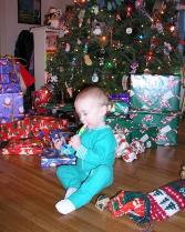 Thomas opens his stocking by the tree