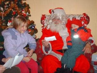 Thomas snuggles in with Santa while Bethan shares her wish list