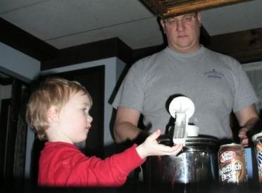 Thomas helps rice potatoes for dumplings