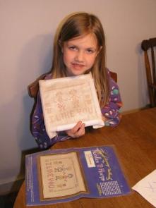 Bethan's learning to cross-stitch.